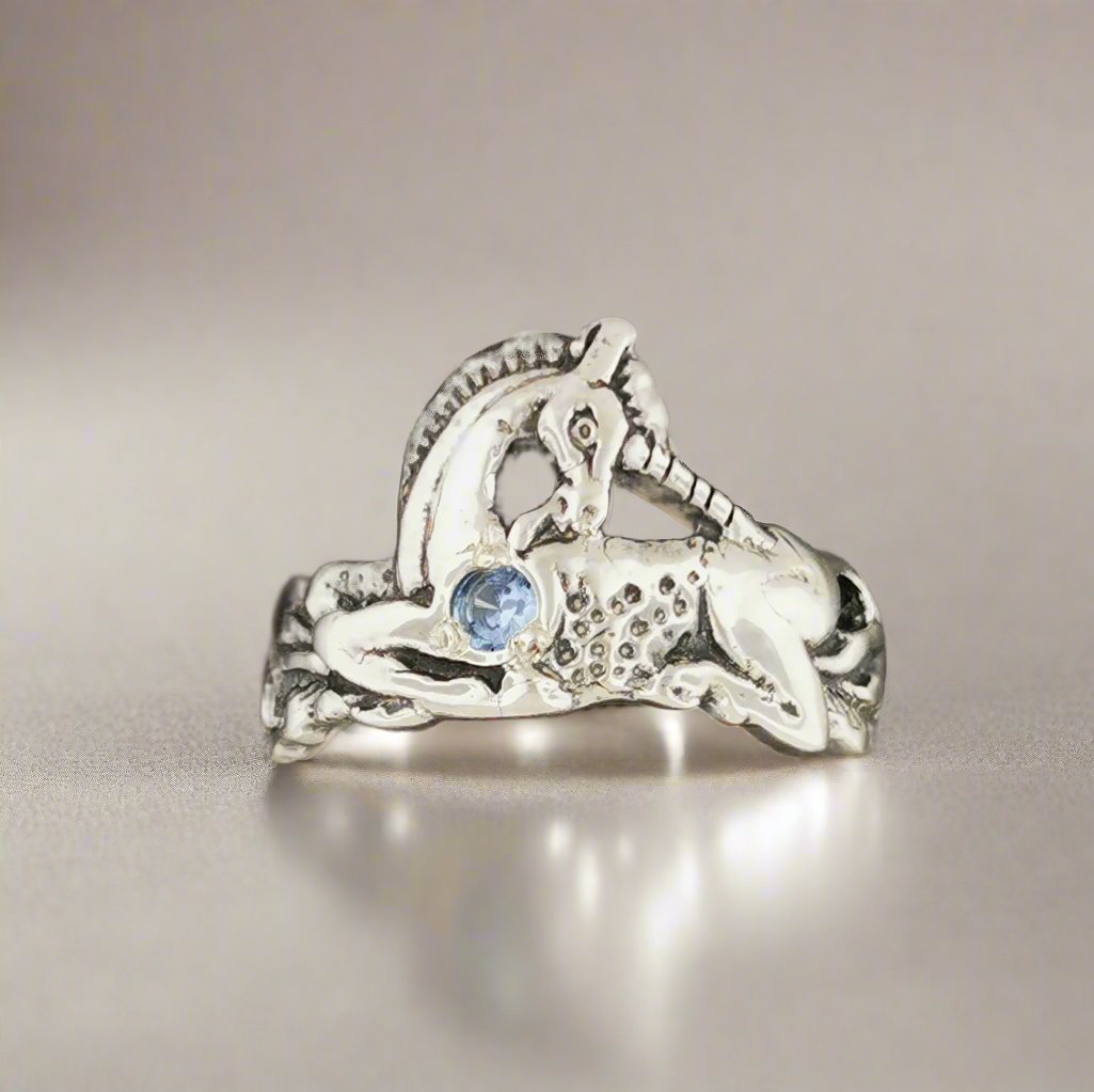 A detailed sterling silver unicorn ring with a vibrant gemstone heart, designed for lovers of unicorn jewelry and fantasy-inspired accessories by Le Dragon Argenté.