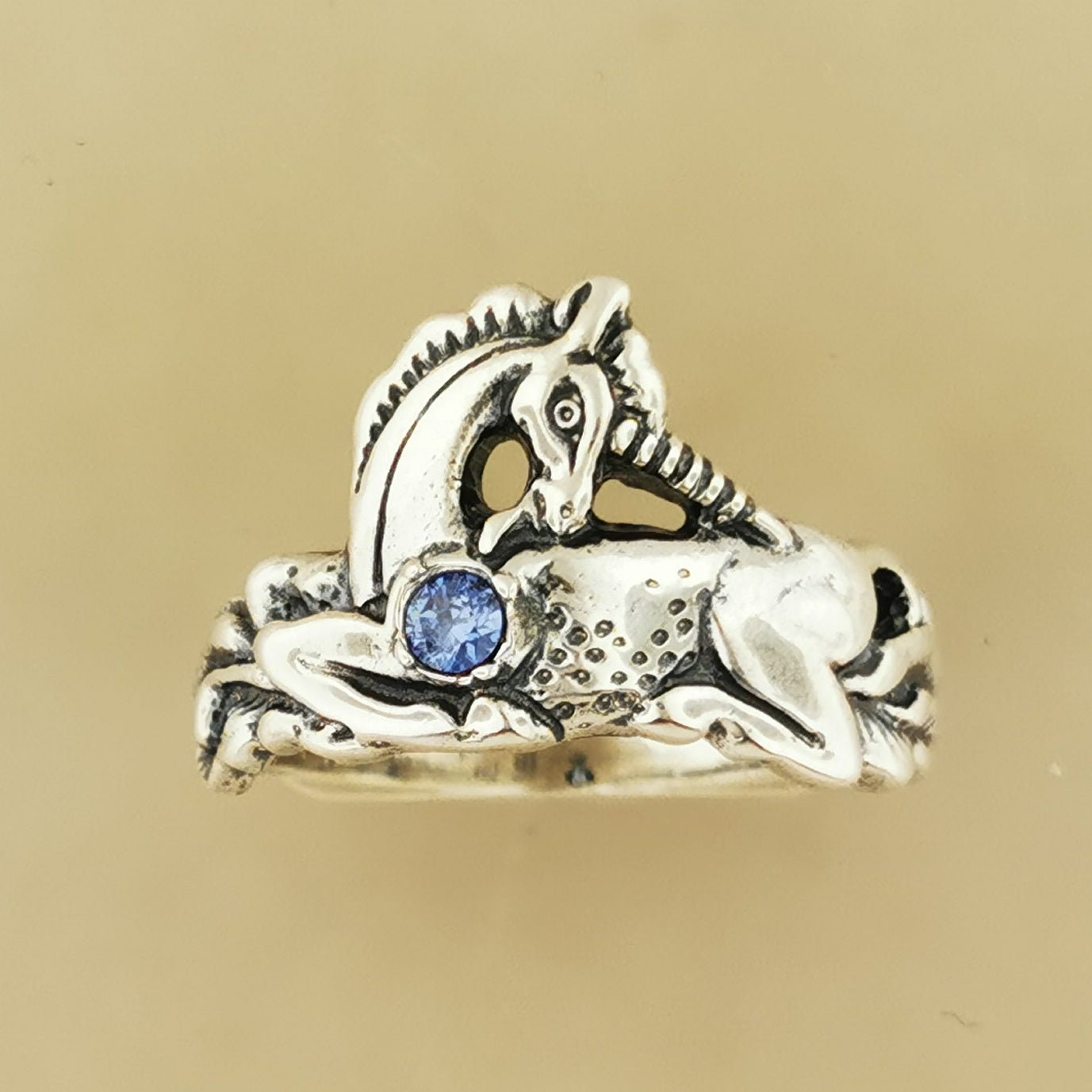 A detailed sterling silver unicorn ring with a vibrant gemstone heart, designed for lovers of unicorn jewelry and fantasy-inspired accessories by Le Dragon Argenté.