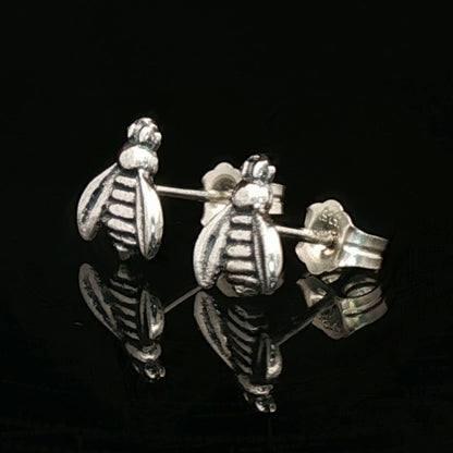 Silver bee-shaped earrings on a black background