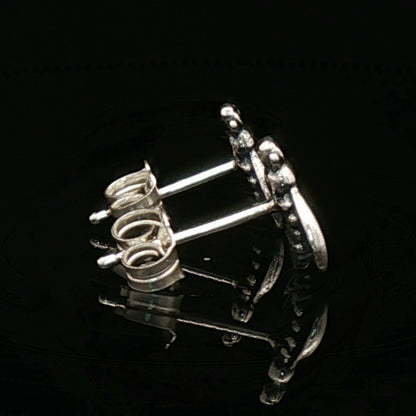 Pair of silver earrings on a black background