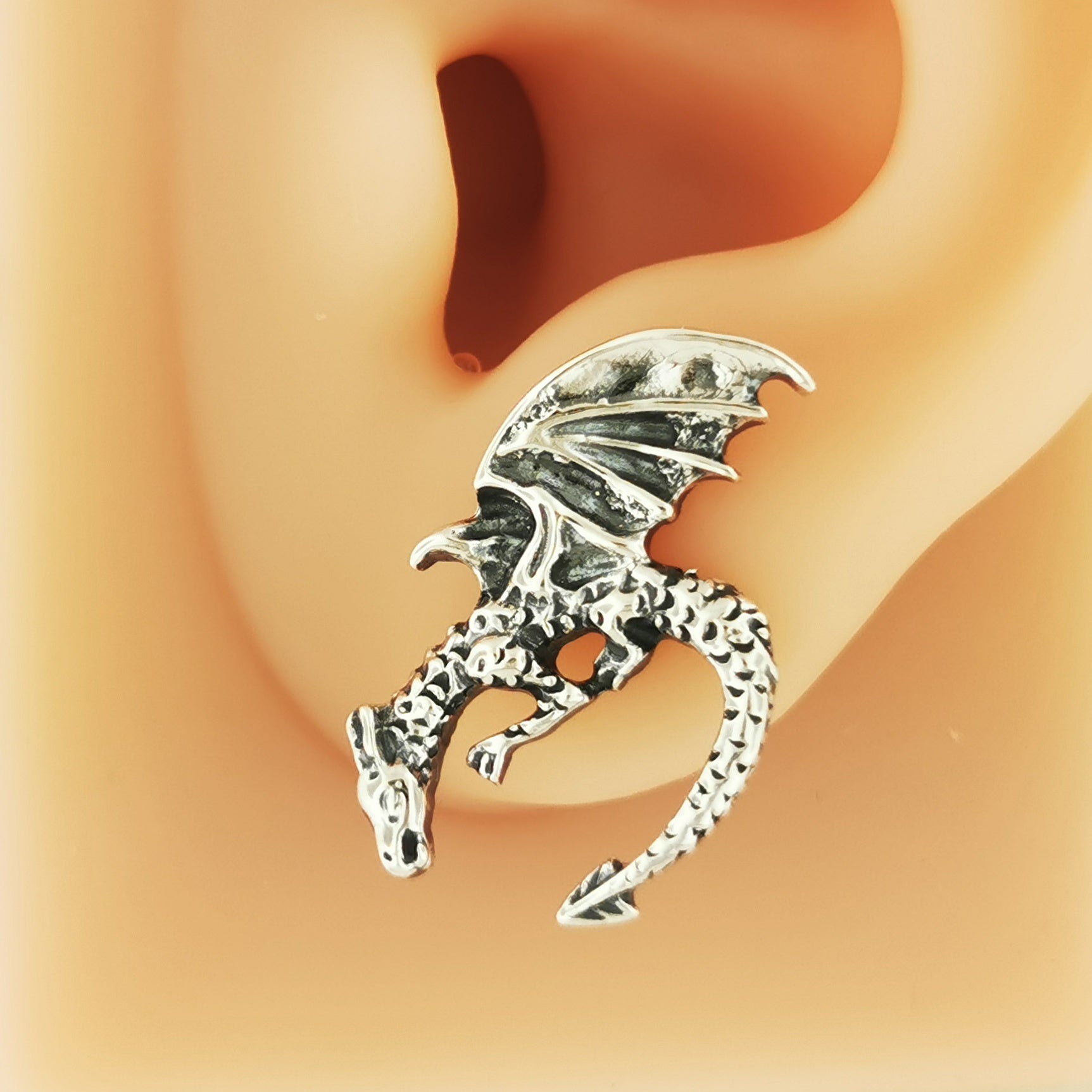 Handmade .925 Sterling Silver Winged Dragon Earrings by Le Dragon Argenté showcased on an earlobe - Jewelry Design Featuring Diving Dragons, Symbolizing Courage, Protection, and the Pursuit of Dreams, Perfect for Mythical Lore Enthusiasts.