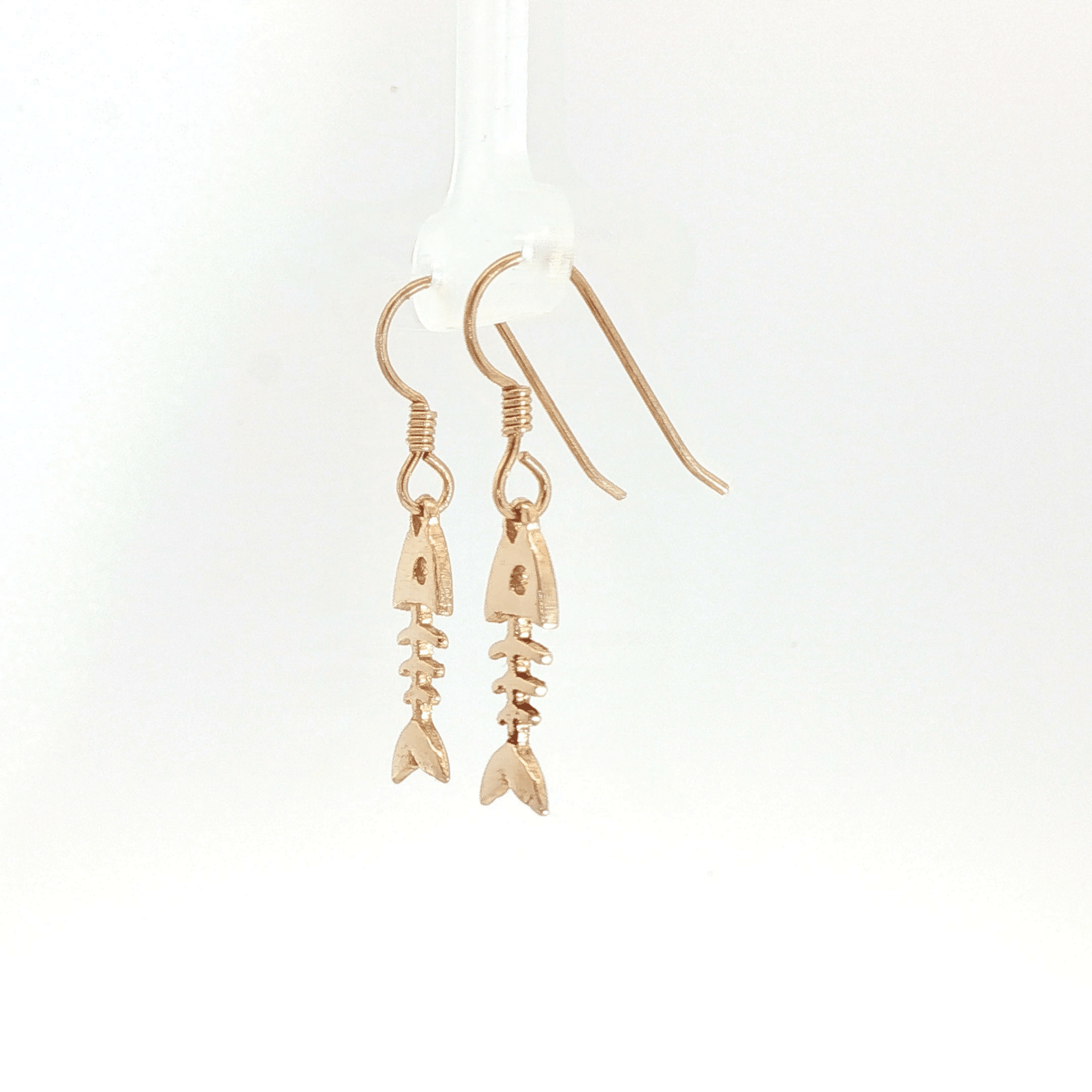 Fishbone charm earrings in antique bronze, quirky ocean jewelry, small fish skeleton dangle earrings, nautical themed animal jewelry, minimalist beach inspired earrings with playful aesthetic by Le Dragon Argenté
