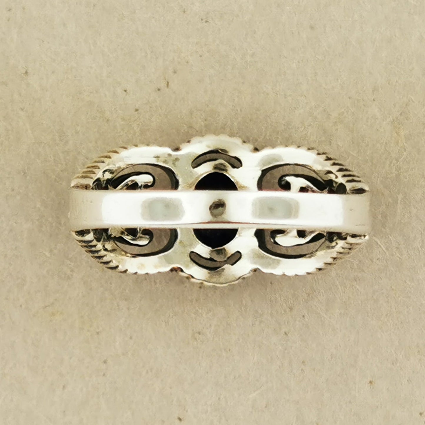 A silver ring with an intricate, decorative design.
