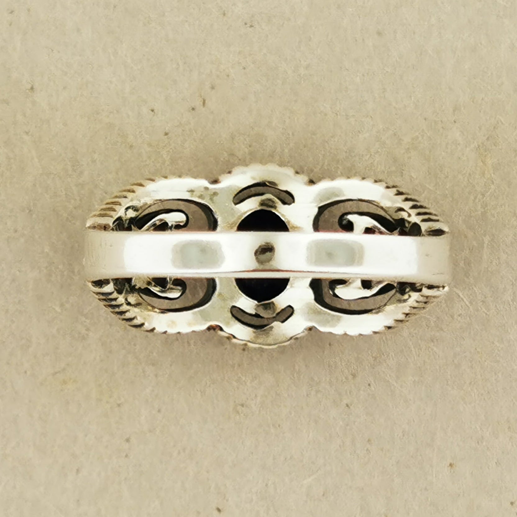 A silver ring with an intricate, decorative design.