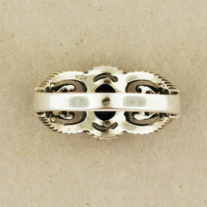 A silver ring with an intricate, decorative design.