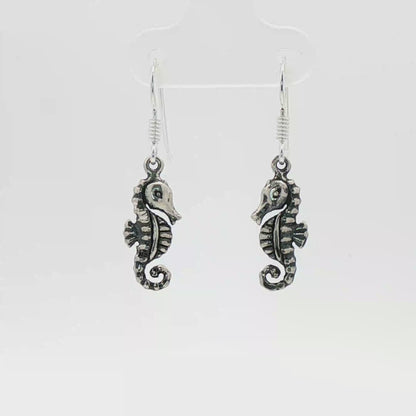 Small abstract seahorse charm earrings in sterling silver, delicate ocean inspired jewelry, minimalist sea life dangle earrings, artistic coastal style earrings, subtle nautical everyday accessory by Le Dragon Argenté
