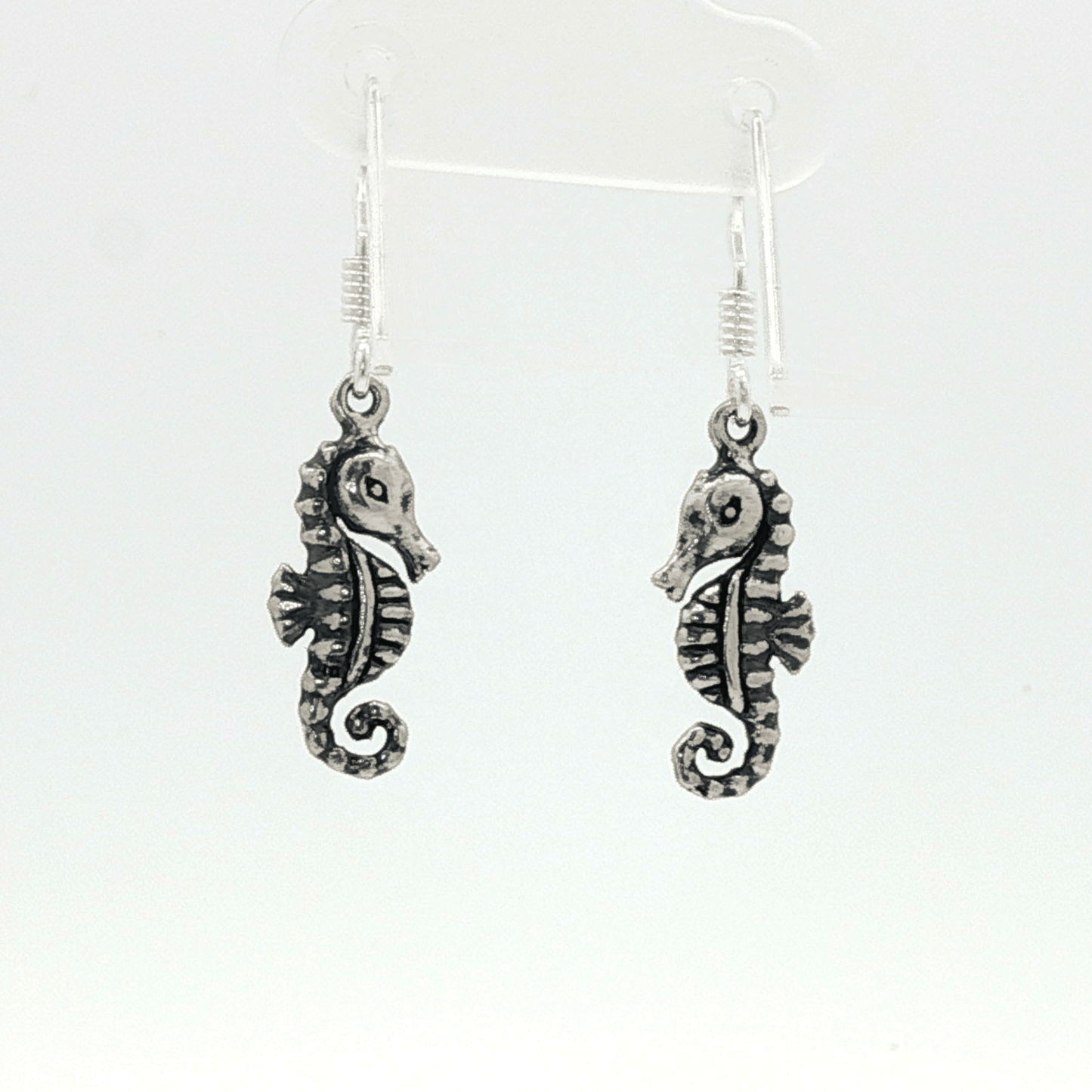 Small abstract seahorse charm earrings in sterling silver, delicate ocean inspired jewelry, minimalist sea life dangle earrings, artistic coastal style earrings, subtle nautical everyday accessory by Le Dragon Argenté