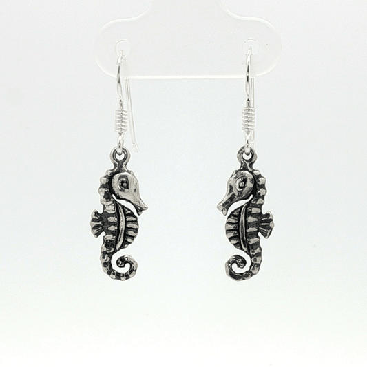 Small abstract seahorse charm earrings in sterling silver, delicate ocean inspired jewelry, minimalist sea life dangle earrings, artistic coastal style earrings, subtle nautical everyday accessory by Le Dragon Argenté