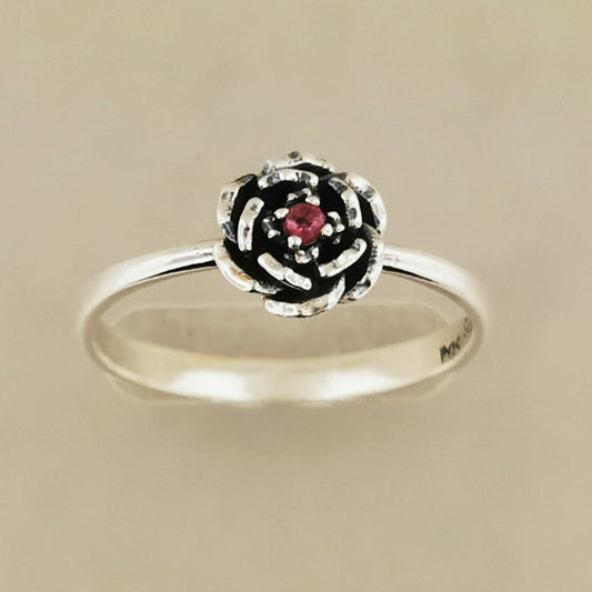 Handmade Small Rose Ring in .925 Sterling Silver featuring a delicate sculpted rose with a 1.5mm coloured cubic zirconia birthstone at its centre. Elegant and dainty yet durable, this floral ring makes a perfect gift of love, promise, or self-expression. Crafted by Le Dragon Argenté in Montreal, Canada.
