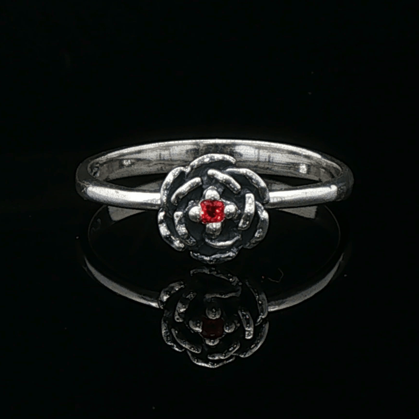 Handmade Small Rose Ring in .925 Sterling Silver featuring a delicate sculpted rose with a 1.5mm coloured cubic zirconia birthstone at its centre. Elegant and dainty yet durable, this floral ring makes a perfect gift of love, promise, or self-expression. Crafted by Le Dragon Argenté in Montreal, Canada.