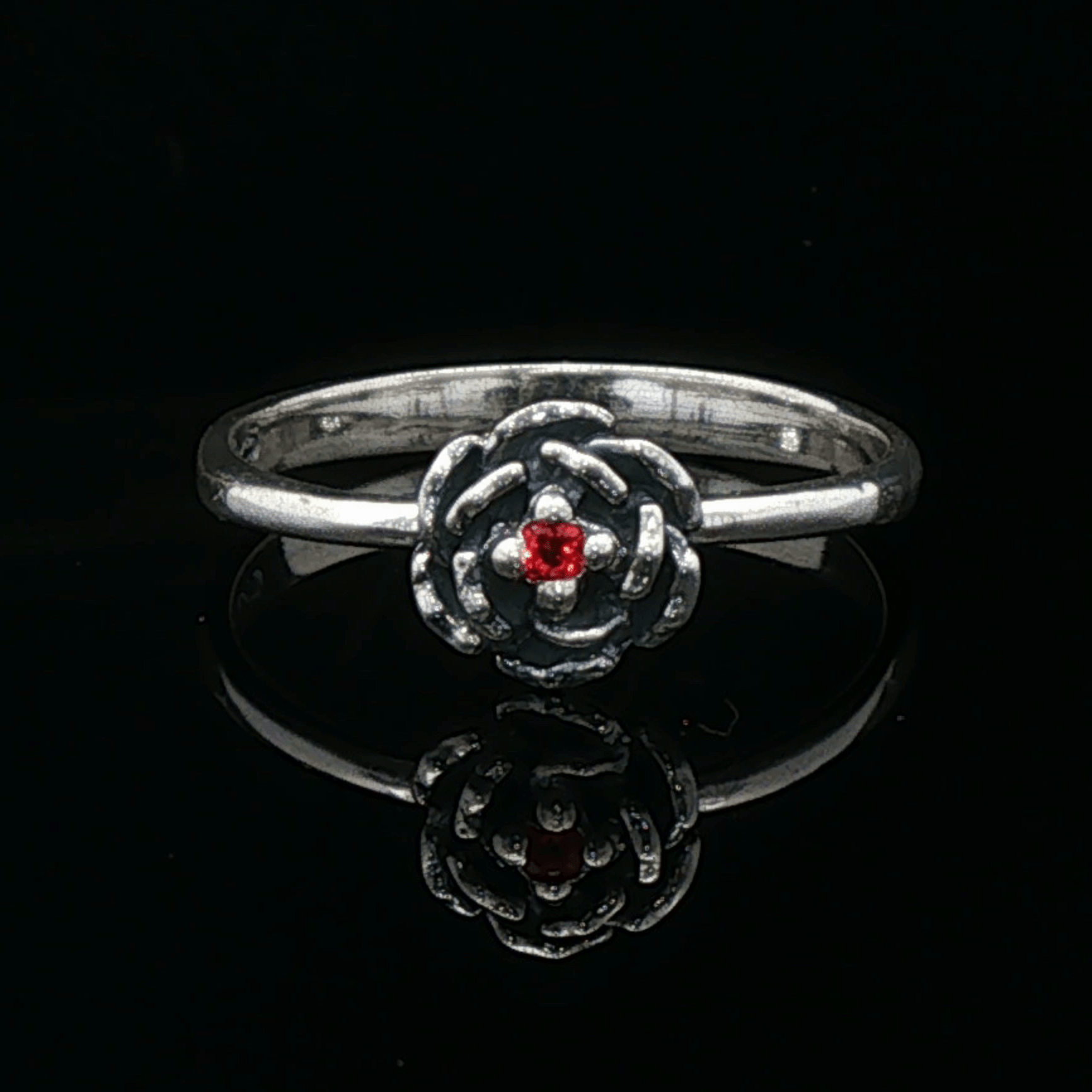 Handmade Small Rose Ring in .925 Sterling Silver featuring a delicate sculpted rose with a 1.5mm coloured cubic zirconia birthstone at its centre. Elegant and dainty yet durable, this floral ring makes a perfect gift of love, promise, or self-expression. Crafted by Le Dragon Argenté in Montreal, Canada.