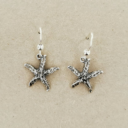 Close-up of silver starfish earrings with beachy charm and style