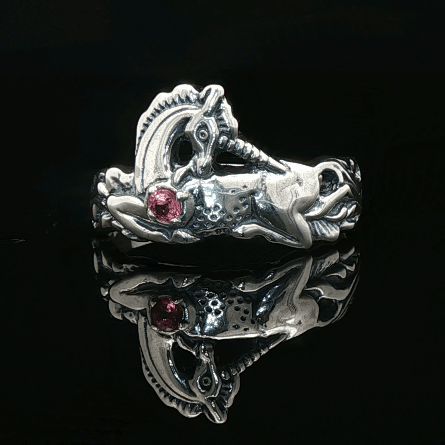 A detailed sterling silver unicorn ring with a vibrant gemstone heart, designed for lovers of unicorn jewelry and fantasy-inspired accessories by Le Dragon Argenté.