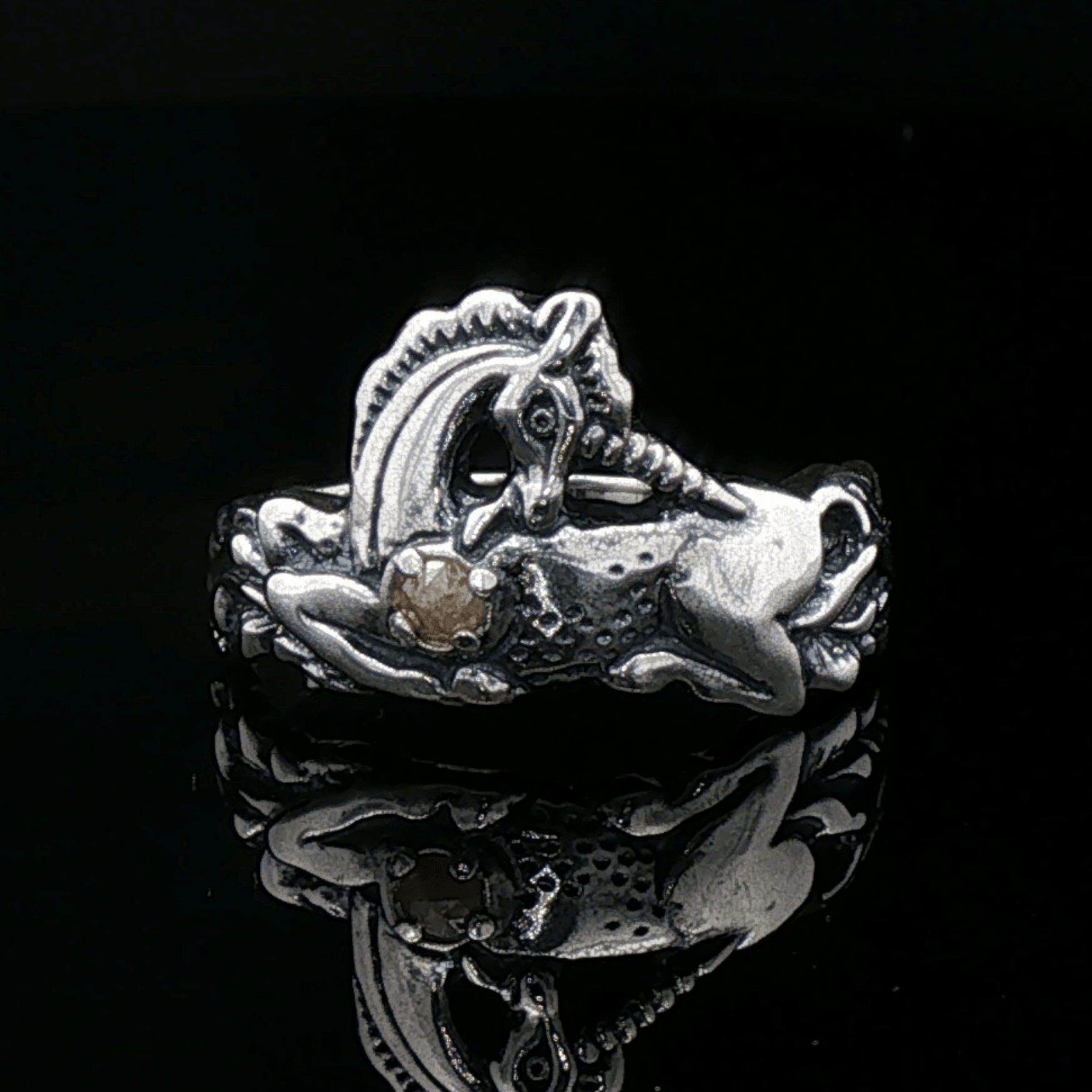 A detailed sterling silver unicorn ring with a vibrant gemstone heart, designed for lovers of unicorn jewelry and fantasy-inspired accessories by Le Dragon Argenté.